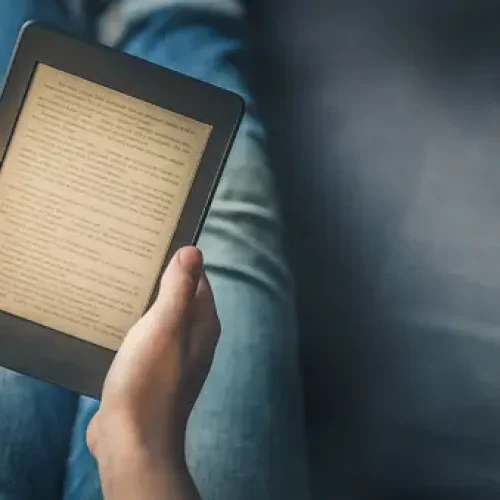 Girl is reading ebook on digital tablet device while relaxing on the sofa Girl is reading ebook on digital tablet device while relaxing on the sofa
